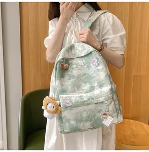 Casual green tie-dye backpack with cute patches shown on a model in a warm room