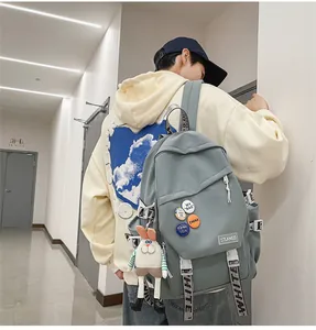 Detail view of a stylish gray large capacity laptop backpack with badges on a model