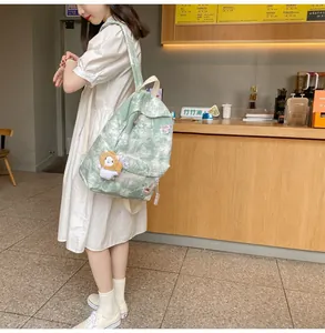 Light green tie-dye backpack with cute patches shown in a casual lifestyle cafe setting