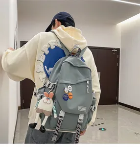 Back view of a gray large capacity student backpack with cute decorative charms