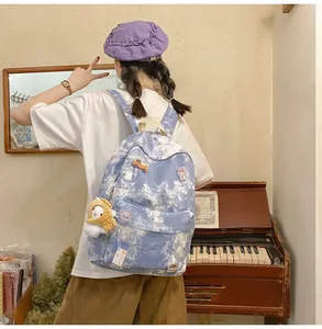 Blue and white tie-dye student backpack with cute pins and lion plushie accessory