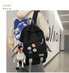 Close-up of a black student backpack with industrial straps and cute rabbit keychain