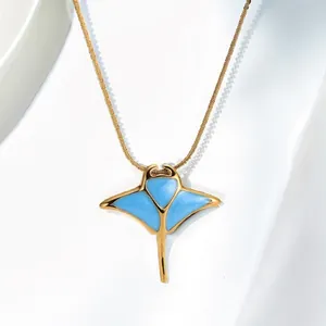 Close-up view of a gold stainless steel manta ray necklace with vibrant blue enamel