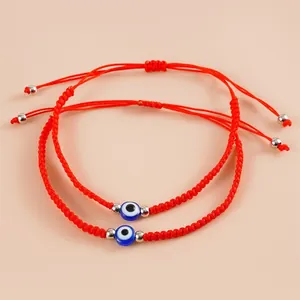 Set of 2 adjustable red braided bracelets featuring Turkish blue evil eye charms