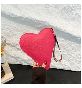 Vue détaillée d'un sac à main rose en forme de cœur avec texture de cuir grainé