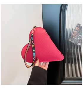 Sac à main rose fuchsia en forme de cœur en cuir grainé avec dragonne LOVE colorée.