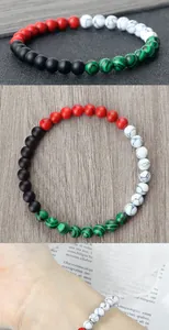 Detailed view of handmade flag color beaded bracelet with red black green white stones