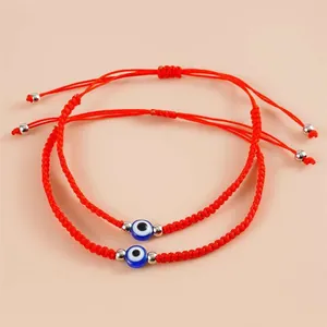 Nahaufnahme von zwei verstellbaren roten geflochtenen Armbändern mit bösem Blick