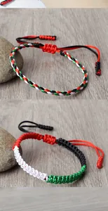 Detail of hand-woven bracelets featuring Palestine and UAE flag colors in braided cord.