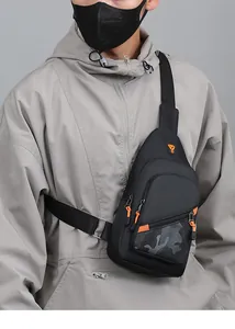 Detailed view of a trendy black men's chest bag worn over a gray hoodie