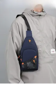 Detailed shot of a stylish navy blue men's chest bag worn by model in a grey casual hoodie