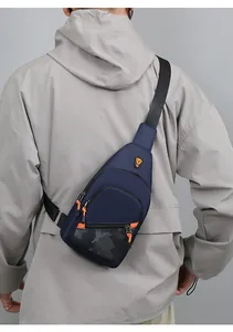 Back view of a male model wearing a navy blue fashion chest bag with orange accent zippers.