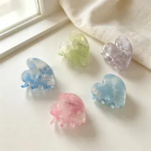 Detailed view of colorful mini heart hair claw clips featuring a glossy marbled finish