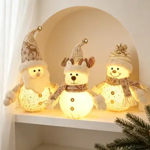Three glowing Christmas fabric dolls featuring Santa Claus, Reindeer and Snowman on a shelf