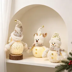 Detailed view of glowing Christmas plush dolls featuring a Santa gnome, reindeer, and snowman.