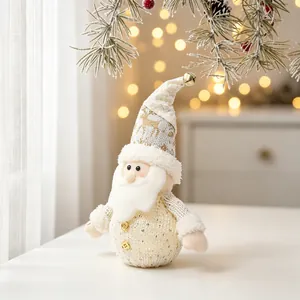 Detailed shot of a glowing Christmas Santa plush doll on a white table with festive lights