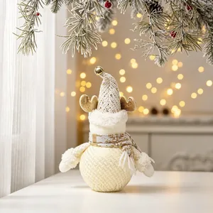 Close-up of a cream-colored fabric Christmas doll with a knitted hat and golden antlers