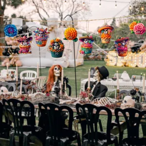 Colorful Day of the Dead cupcake and flower ornaments hanging in a festive garden