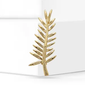 Gold palm leaf brooch accessory with polished metallic finish and intricate details