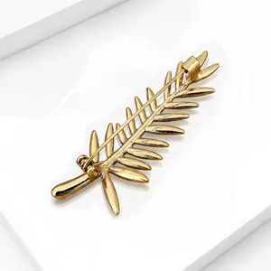 Detailed macro view of the back pin mechanism on a gold palm leaf brooch for suit accessory.
