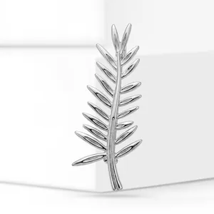 Close-up detail of a polished silver leaf-shaped brooch pin with elegant metallic finish
