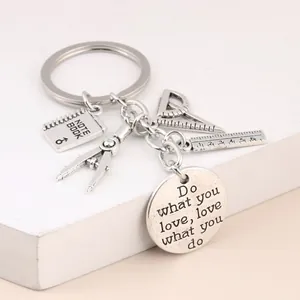 Silver-toned teacher keychain featuring miniature educational charms and an inspirational quote disc