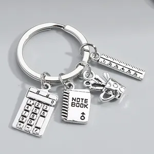 Detailed macro view of school-themed charms on a silver teacher gift keychain, silver color