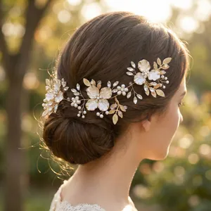 Elegant gold bridal hair comb featuring handmade white flowers, pearls, and clear rhinestones.