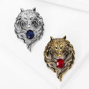Close-up detail of vintage antique wolf head brooches with sparkling red and blue crystals.