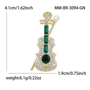 Elegante spilla a violino con cristalli verdi e perla, mostrata con le misure.