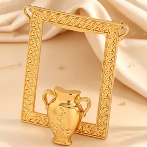 Nahaufnahme einer goldfarbenen Bilderrahmen-Brosche mit Vasendetail und Gravuren