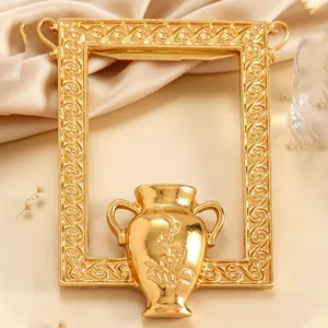 Detaillierte Nahaufnahme einer eleganten Goldrahmen- und Vasenbrosche mit Vintage-Mustern