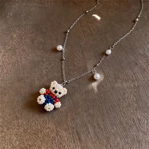 Close-up view of a cute handmade beaded bear pendant necklace with elegant pearl accents