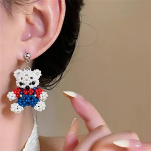 Close-up of a cute beaded bear earring worn on ear showing intricate handmade details