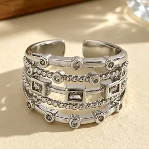 Macro detail of a multilayer silver-tone ring with square and round cubic zirconia.