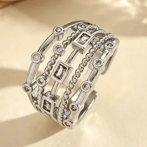 Macro detail of multi-layer silver ring with woven bands and inlaid zircons