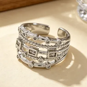Detailed close-up of a silver multi-layered woven ring with geometric cubic zirconias.