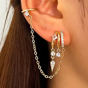 Close-up of gold ear cuff and huggie earrings with cubic zirconia and chain