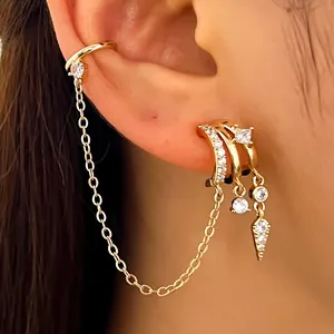Elegant gold-toned ear cuff and chain earring set with sparkly zircons and drop details.