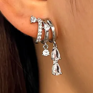 Close-up detail showing a silver-colored irregular zircon tassel cuff earring worn on the ear