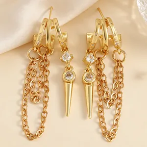 Detailed macro shot of gold tassel hoop earrings with zircon stones and spike charms