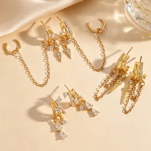 Detailed view of golden spike and tassel earrings embellished with cubic zirconia