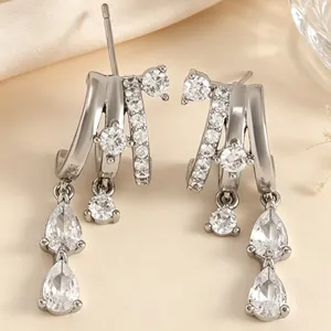 Detail of silver-tone tassel earrings with multi-layered hoops and teardrop zircons