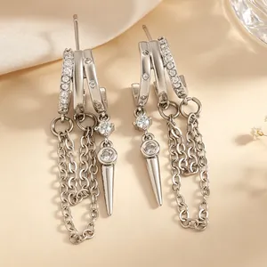 Close-up of silver-tone hoop earrings with zircon pavé, chain tassels, and rivet pendants.