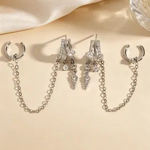 Detailed view of silver fringe earrings with cubic zirconia and chain link ear cuffs.