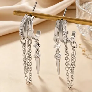 Detailed view of silver tassel hoop earrings with zircon stones and spike pendants.