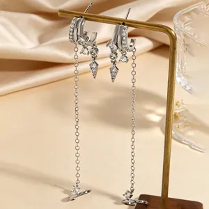 Close-up of irregular silver tassel hoop earrings with sparkling cubic zirconia