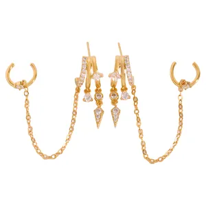 Close-up detail of stylish gold tassel hoop earrings featuring sparkling zircons and chains