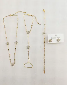 Vista detallada del conjunto de joyas de acero inoxidable dorado con flores y cristales