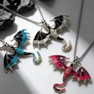 Detail shot of three gothic dragon necklaces in blue, black, and pink enamel finishes